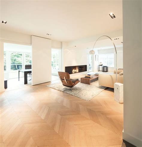 A Living Room With Wood Floors And White Furniture In Front Of An Open