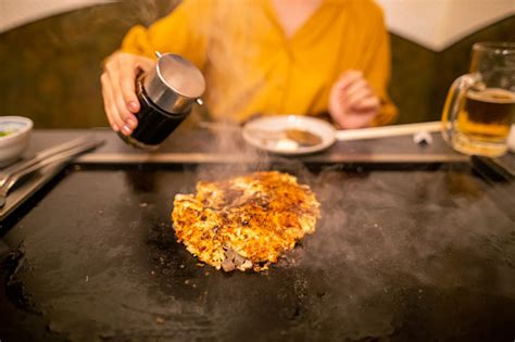 Wanita Muda Memasak Okonomiyaki Jepang Di Griddle Foto Stok Unduh