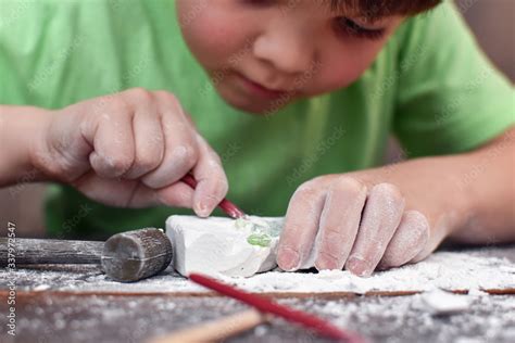 Children having fun with archaeology excavation kit. Boy plays an ...