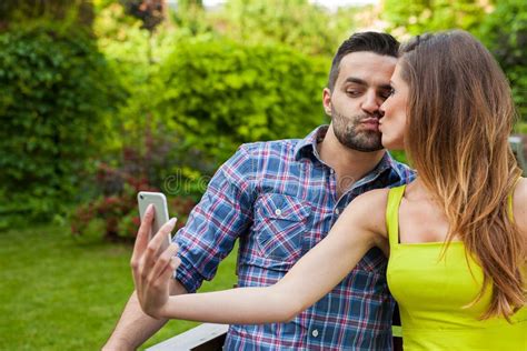 couple sitting   bench   garden   selfie stock