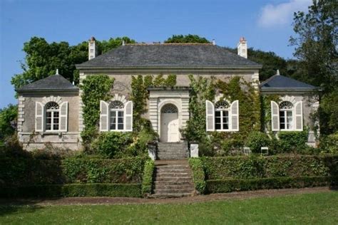 An Old House With Ivy Growing All Over It