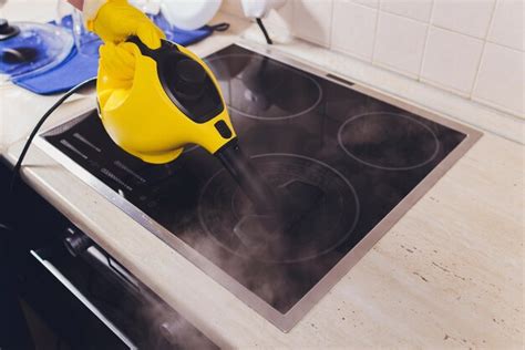 Premium Photo | Cleaning kitchen hob with a steam cleaner