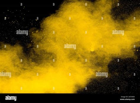 Yellow dust particles explosion on black background.Yellow powder ...