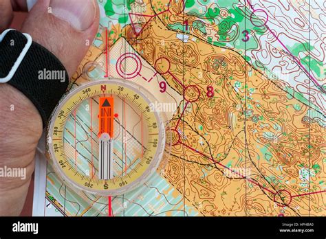 Hand Holding A Compass On An Orienteering Map Stock Photo Alamy