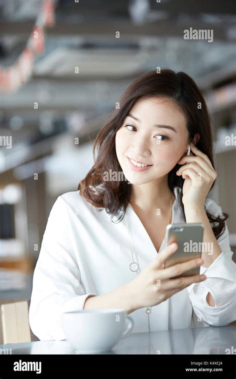 Japanese Woman With Smartphone In A Stylish Cafe Stock Photo Alamy