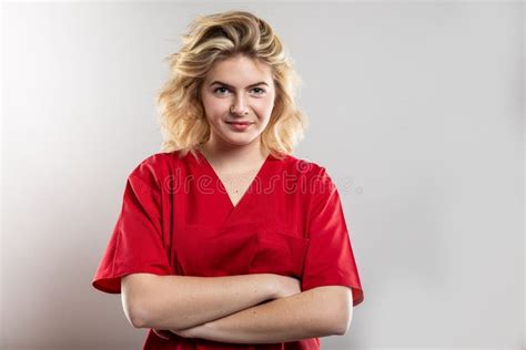 Portrait Of Nurse Wearing Red Scrub Standing With Arms Crossed Stock