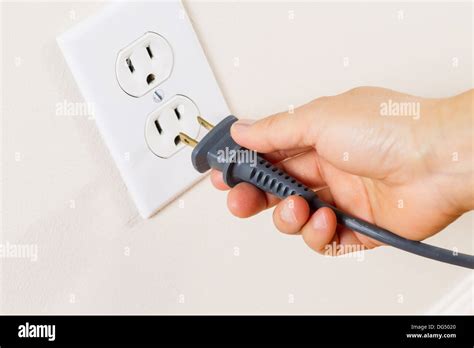 Horizontal Photo Of Female Hand Inserting Power Cord Receptacle Into