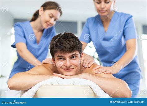 Two Female Masseurs Massaging A Man In Spa Complex Stock Image Image