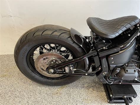 A Black Motorcycle Parked In A Room Next To A Wall