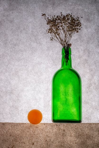 Premium Photo Still Life With A Green Bottle With Flowers And An