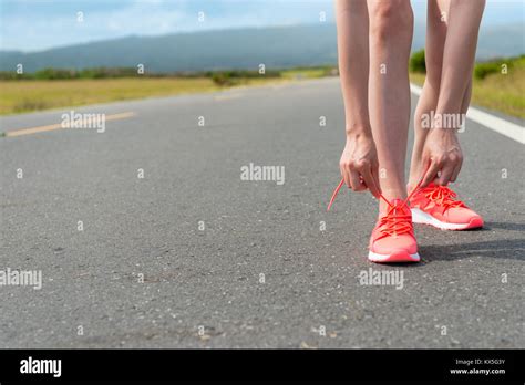 Female Runner Tying Shoelace Ready To Workout On Road Stock Photo Alamy