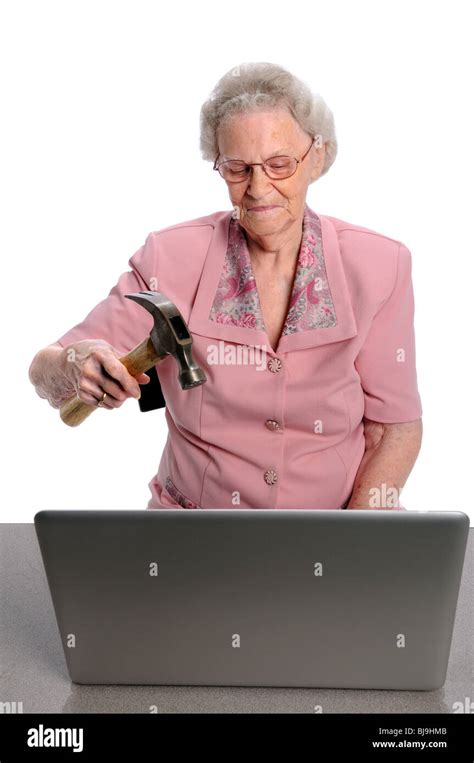 Elder woman breaking laptop computer with hammer Stock Photo - Alamy