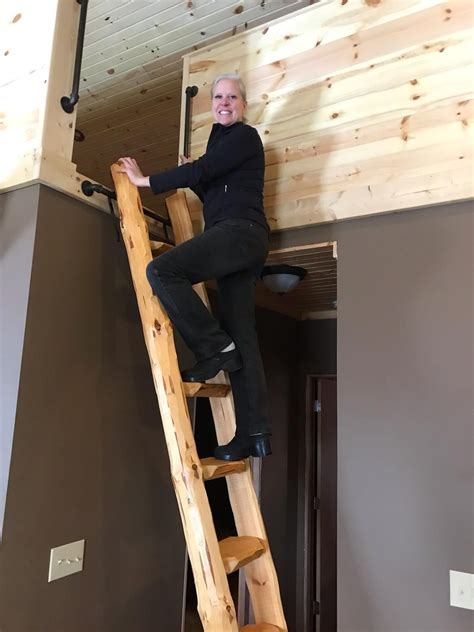 A Man Standing On Top Of A Wooden Ladder