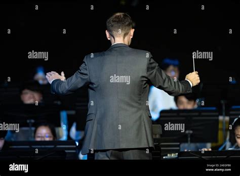 Back View Of A Male Band Conductor In Formal Suit Conducting His