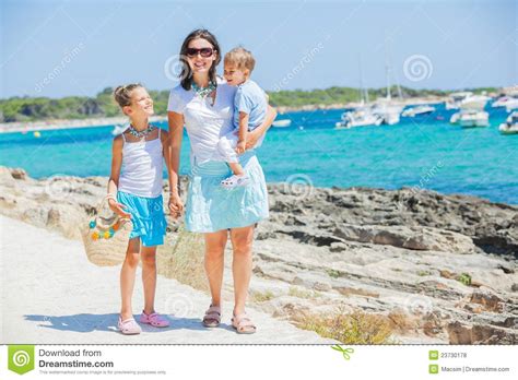 Familia De Tres Que Recorre A Lo Largo De La Playa Tropical Foto De