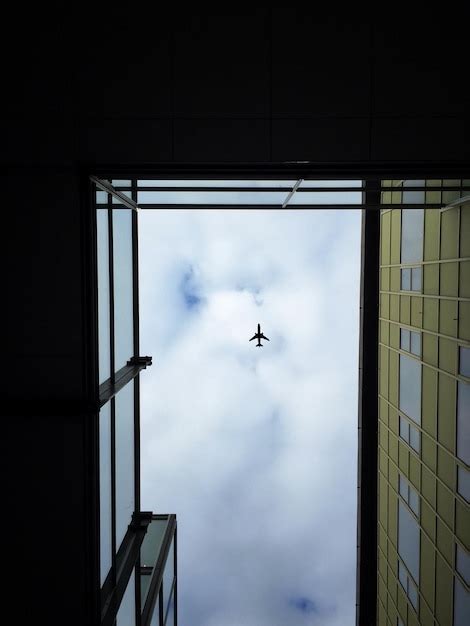 Premium Photo Directly Below Shot Of Airplane Flying Over Buildings