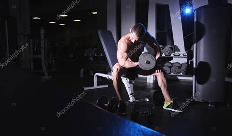 Muscular hombre atlético fuerte con el torso desnudo bombeando los