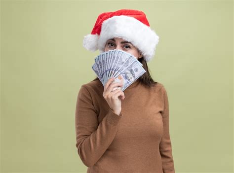 Feliz joven hermosa niña con sombrero de navidad con la cara cubierta