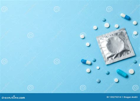 Birth Control Pills And Condom In Package On Blue Concept Of Choosing