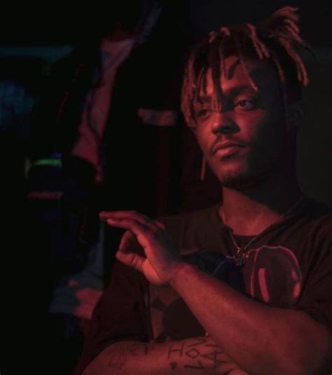 A Man With Dreadlocks Standing In A Dark Room Holding His Hand Out To