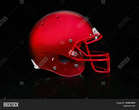 Side View Of A Red Football Helmet On A Black Background Stock Photo