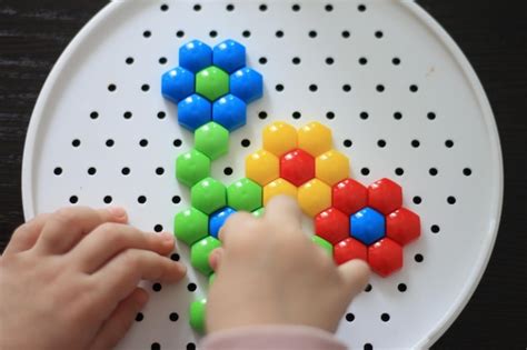 Un niño juega con una pelota de colores hecha de esferas de colores