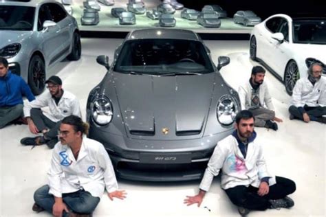 Chez Porsche des militants écolo se collent la main au sol le patron