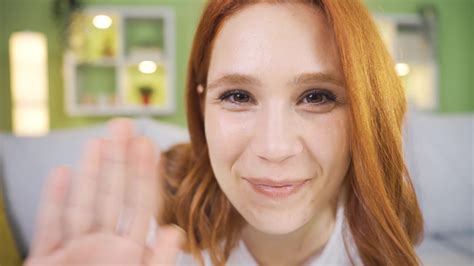 Close Up Portrait Of Cute And Playful Young Woman Waving At Camera