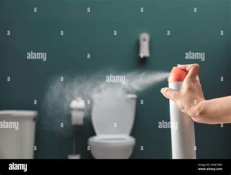 Woman spraying air freshener in bathroom Stock Photo - Alamy