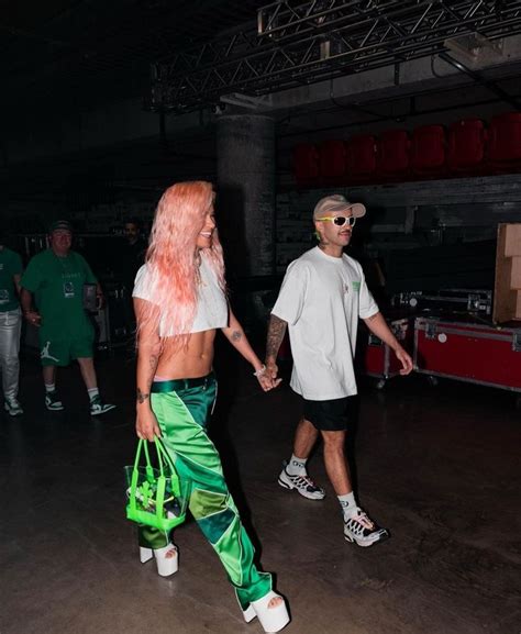 A Man And Woman Holding Hands While Walking