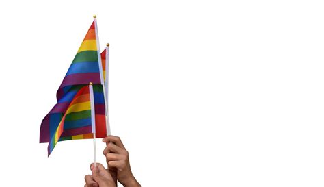 Pride Rainbow Lgbt Gay Flags Holding In Hand And Being Waved In The Breeze Against Blue Sky