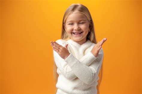 Portrait De Petite Fille Aux Bras Croisés Sur Fond Jaune Photo Gratuite