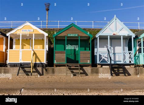 Traditional Seaside Beach Huts With A Brilliant Blue Sky Backdrop On