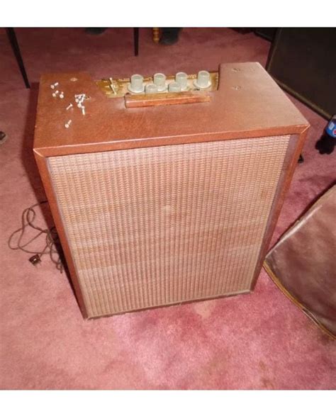 An Old Radio Sitting On The Floor Next To A Table With Some Glass