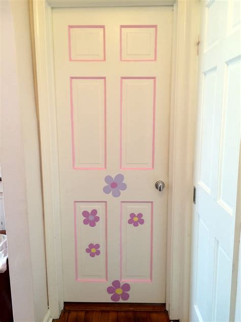 A White Door With Pink And Purple Flowers Painted On The Front Side