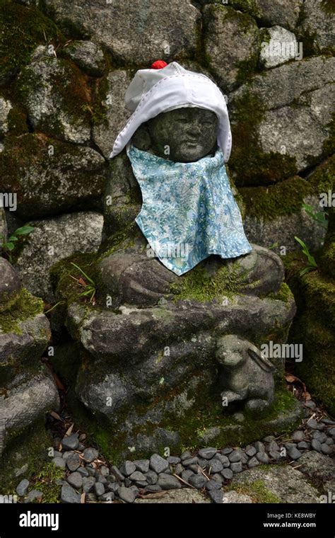 The Statue Of Baby Buddha Wearing Hat And Cute Clothes While Sittin On