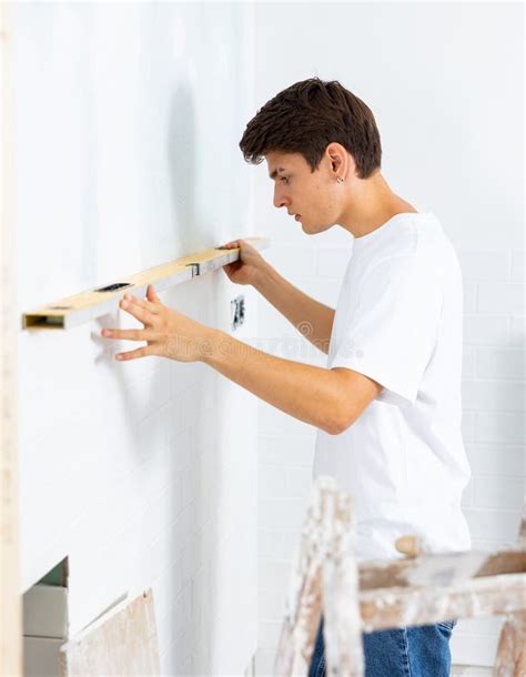 Hombre Que Mide La Planicie De La Pared Con Herramienta De Nivel De