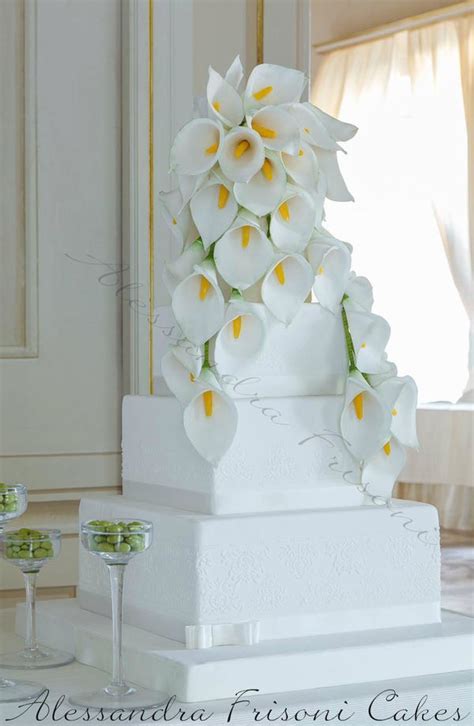 A White Cake With Yellow Flowers On Top And Two Wine Glasses Sitting