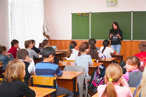 Crianças Da Escola Na Sala De Aula Que Senta se Em Suas Mesas E Para