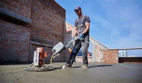 Worker Leveling Concrete Slab Using Special Machine Stock Image