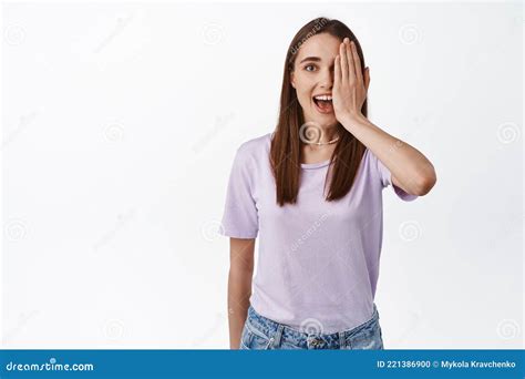 Image Of Surprised Girl Looks With One Eye Half Of Faces Covered With