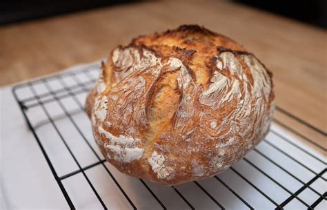 Freshly Baked Loaf Of Bread Rests On Wire Cooling Rack Stock Photo