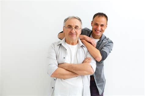 Padre Mayor Con Hijo Adulto Sobre Una Pared Blanca Foto Premium