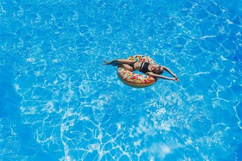 Hermosa Mujer Con Gafas De Sol En La Piscina Flota En Un Anillo De