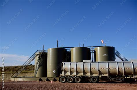 Oil tanker truck loading crude oil for transport, well site production ...