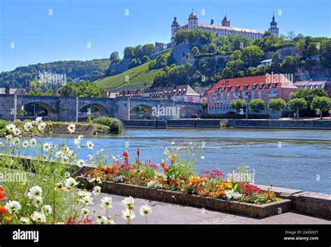 Border Of Flowers On The Main Shore With Old Main Bridge And The