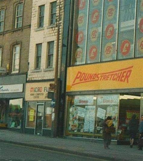 people are walking down the street in front of stores