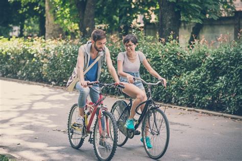 Premium Photo Couple Of Friends Young Man And Woman Riding Bike