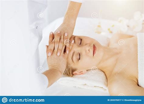 Beautiful Caucasian Woman Enjoying Facial Massage With Closed Eyes In