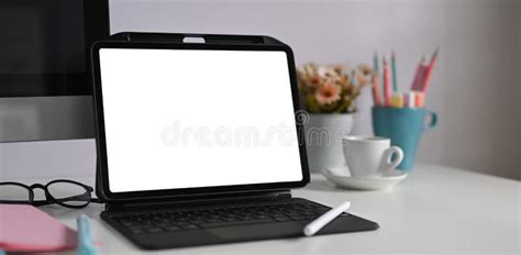 A Computer Tablet With A Keyboard Case Is Putting On A White Working